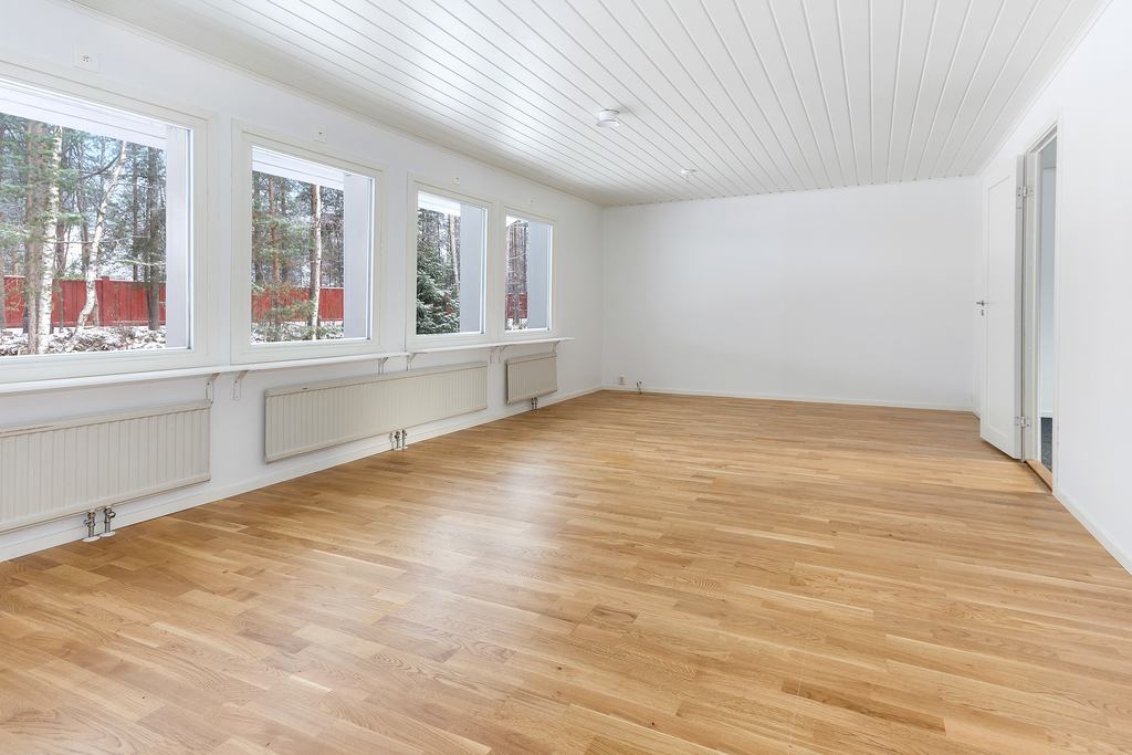Stort luftigt vardagsrum med sovrum till höger.
