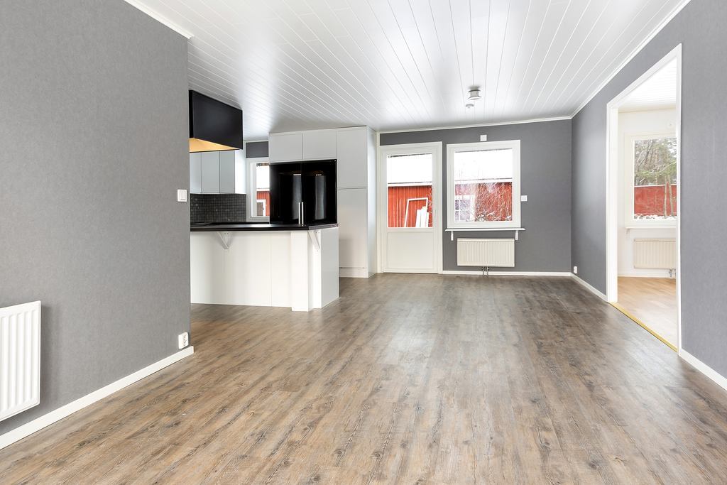 Bred och välkomnade hall, kök och matplats rakt fram.