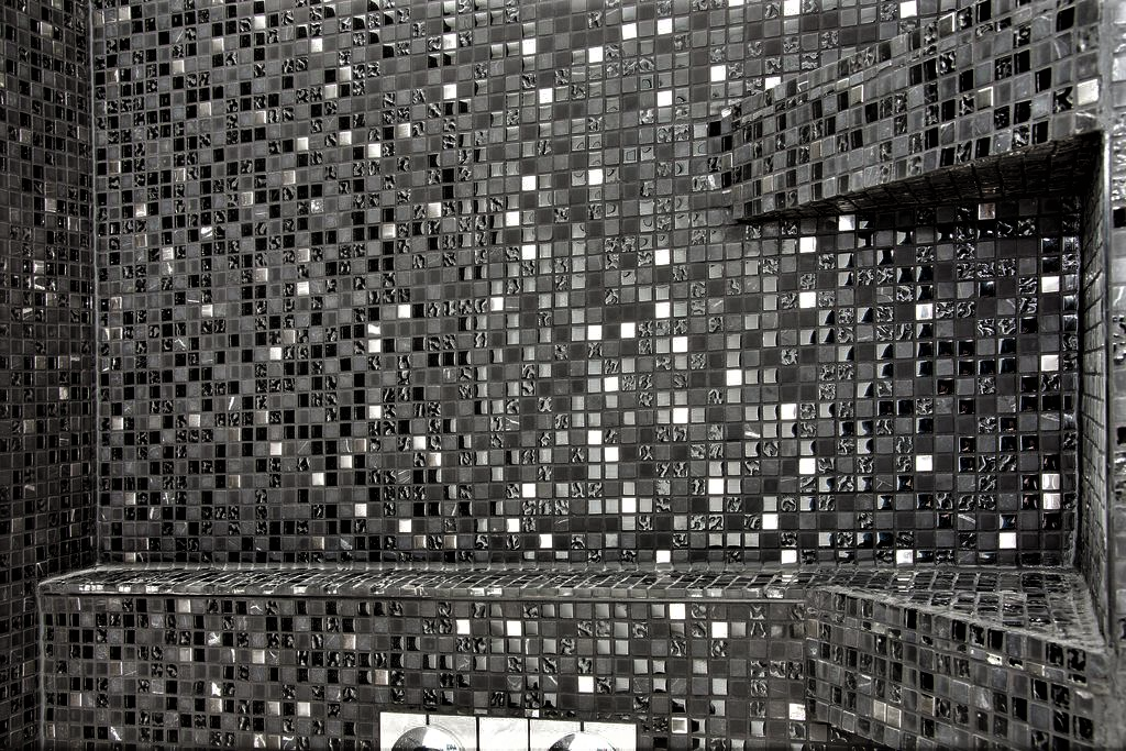 Vacker mosaik och smart hylla för schampo i duschen.